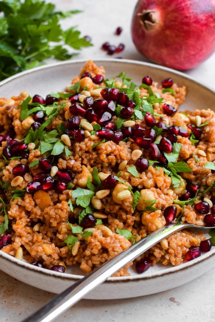 Close up of a bulgur wheat salad with parsley and pomegranate.