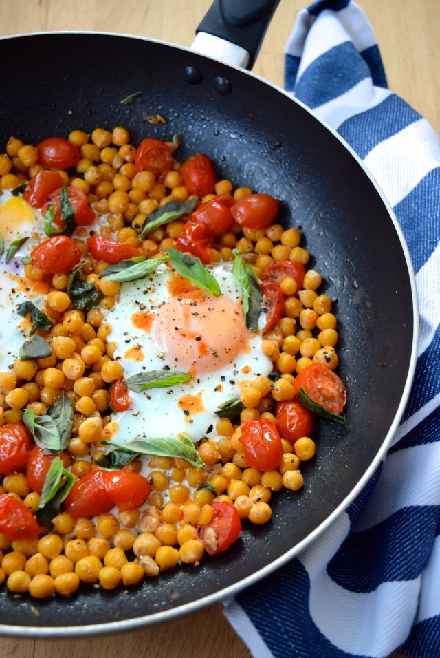 Pan of spiced chickpeas baked with eggs and cherry tomatoes.