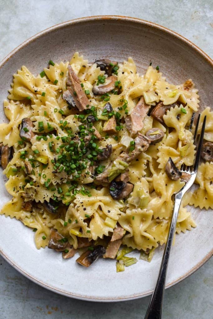 Stone bowl of pork, mushroom and leek pasta in a light creamy sauce.