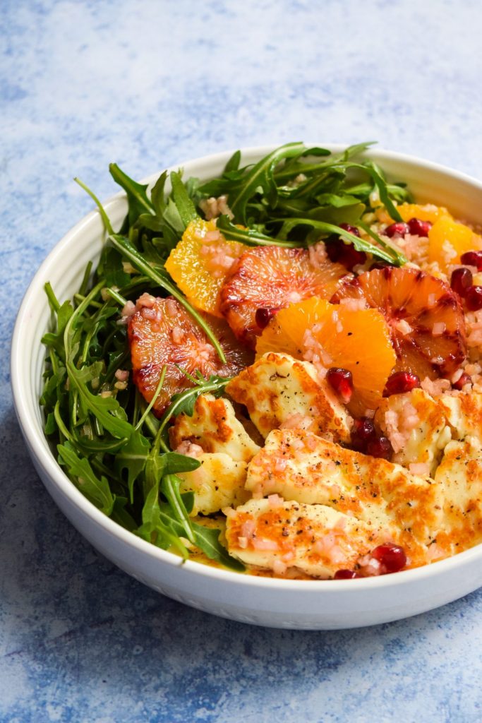 Bowl of griddled halloumi, sliced blood oranges, pomegranate seeds and rocket.