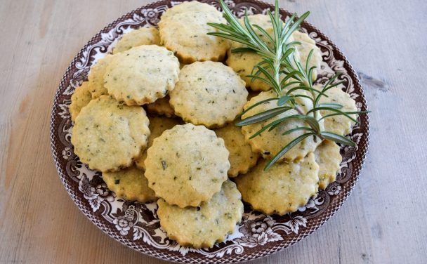 Vintage plate of shortbread garnished with a fresh rosemary sprig.