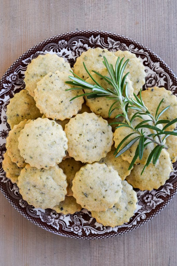 Plate of rosemary parmesan biscuits on a wooden table.