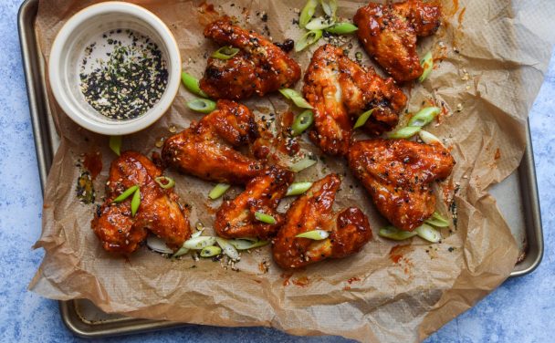 Air fryer korean chicken wings on a brown parchment lined baking tray.