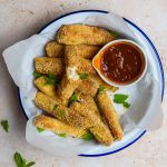 Bowl of air fryer halloumi fries with chilli ketchup and fresh mint.