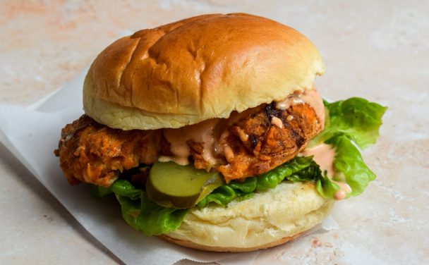 Close up of an air fryer chicken sandwich with lettuce and kosher pickles.