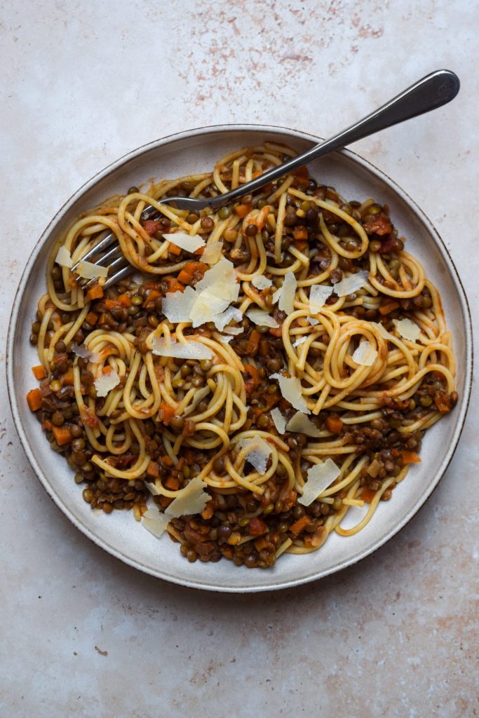 Lentil bolognese with green lentils in a bowl bowl of spaghetti.