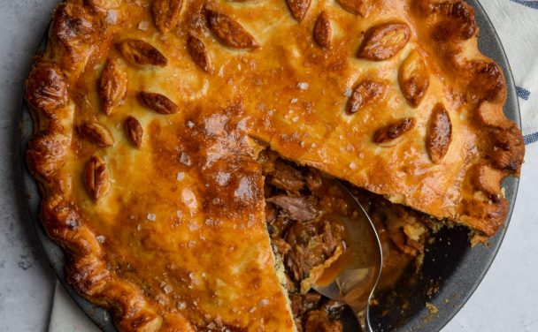 Close up of a steak and ale pie with a slice taken out of it.