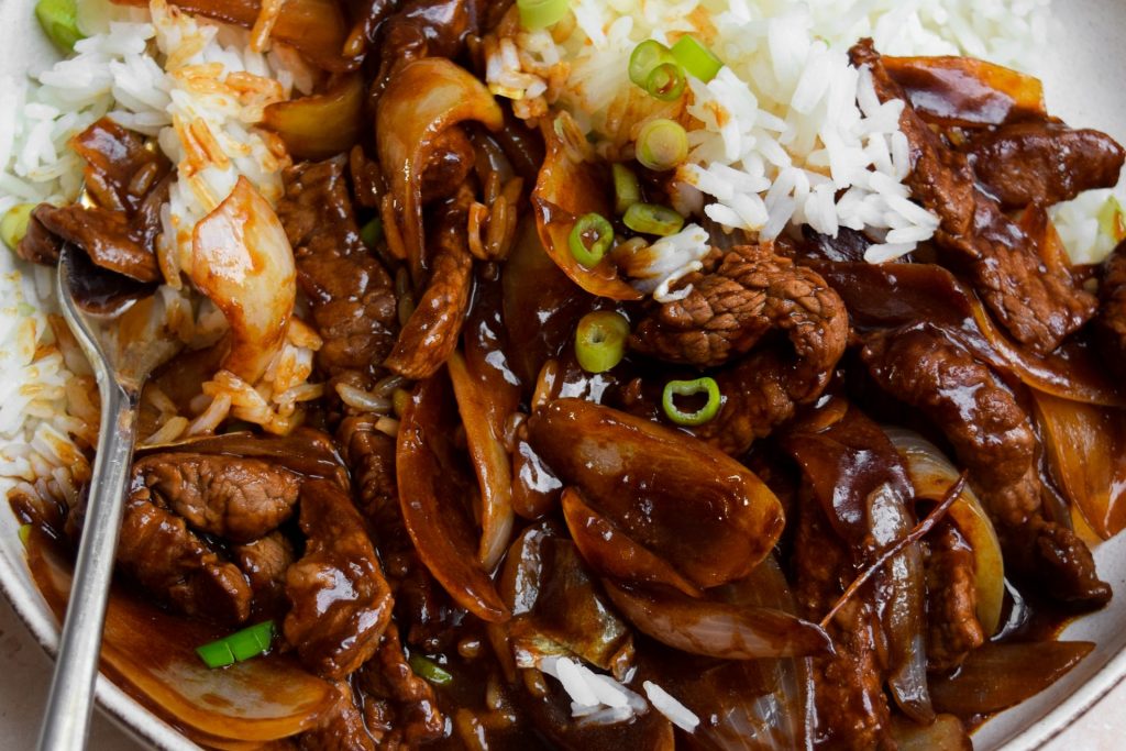 Close up of rice with beef and onions.