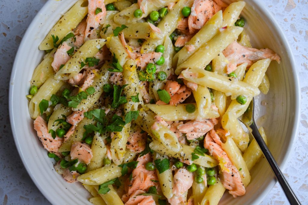 Close up of a bow of salmon pea pasta.