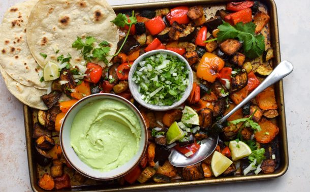Sheet pan vegetable tacos served with avocado crema and charred tortillas.