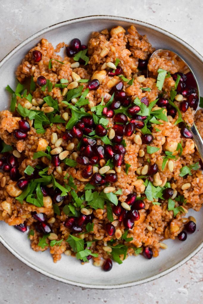 Close up of a bulgur wheat salad with parsley, pine nuts and pomegranate.