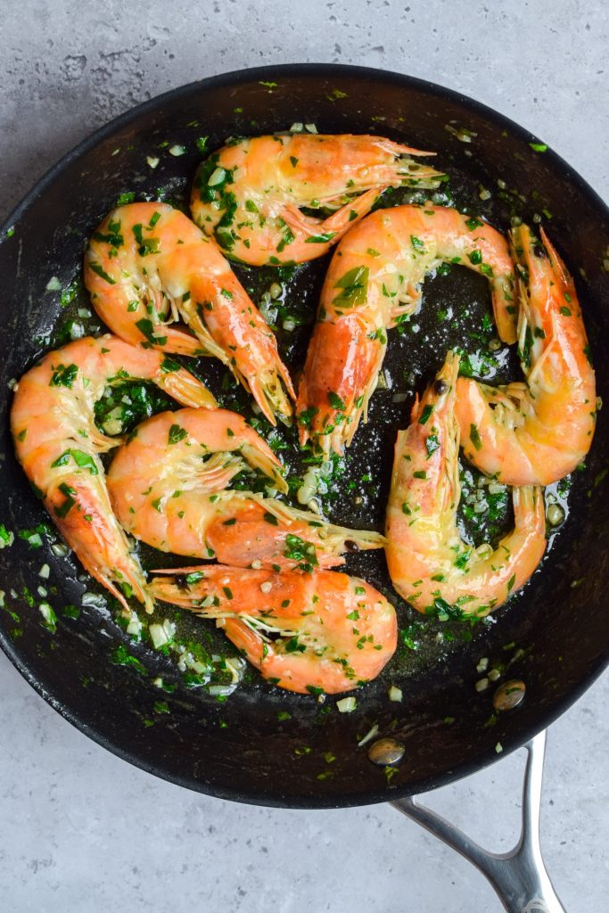 Prawns in a frying pan with garlic butter.