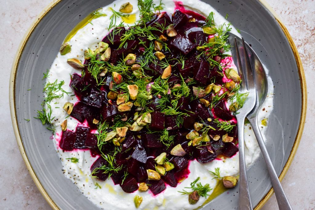 Close up of a bowl of whipped feta piled up with cubed beetroot.