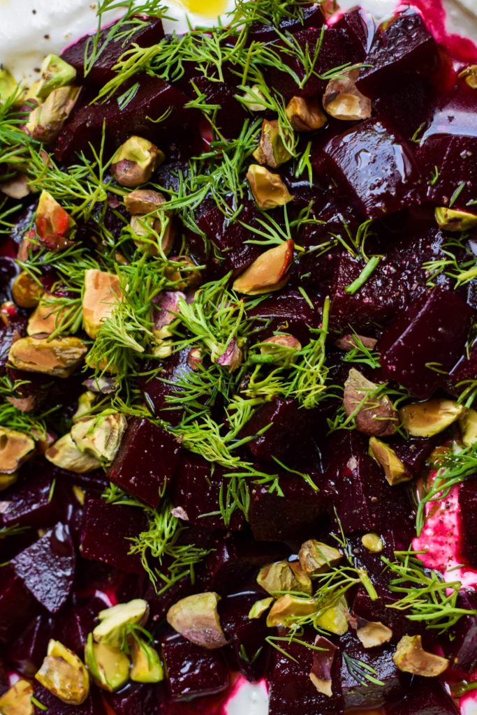 Clos eup of cubed beetroot with dill and pistachios.