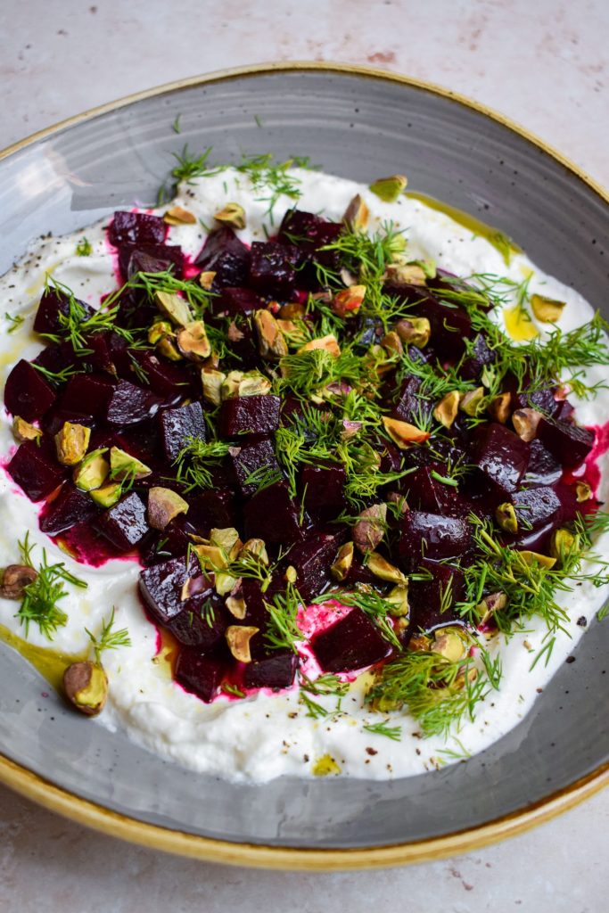 Dill and nuts scattered over a beetroot and feta salad.