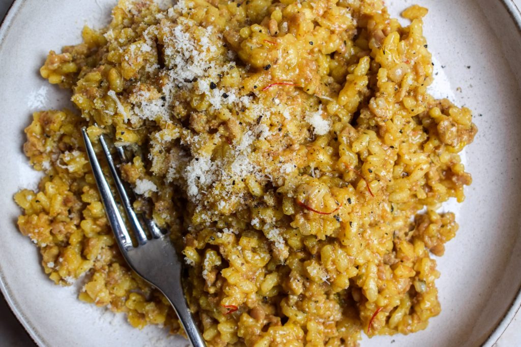 Risotto with sausage and saffron strands on a stone plate