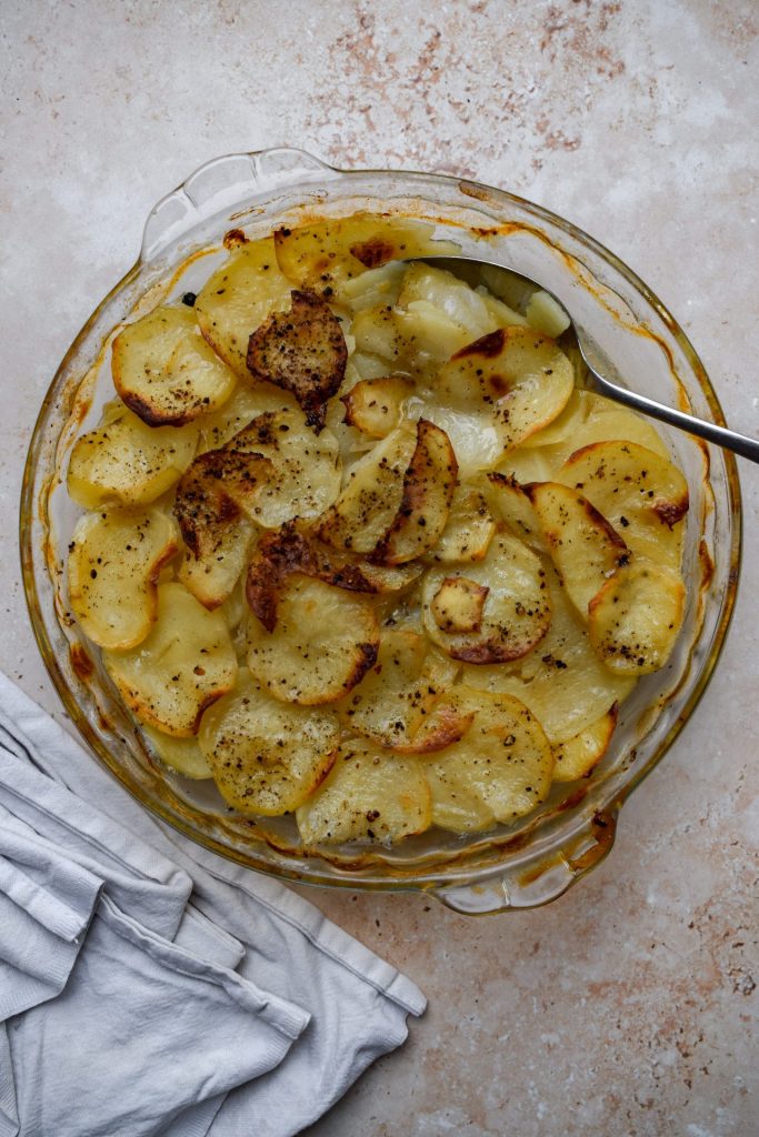 Potatoes Boulangere in a glass baking dish.