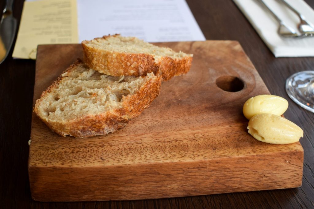 Bread and butter on a wooden board.