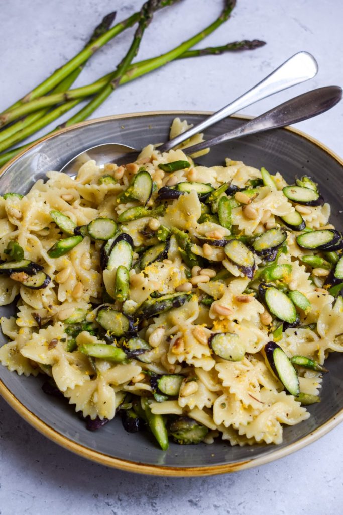 Asparagus Pasta Salad with thin asparagus spears in the background.