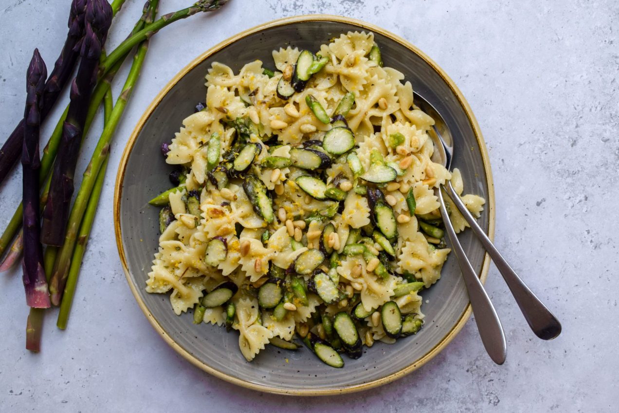 Grey bowl of pasta salad with shaved asparagus.