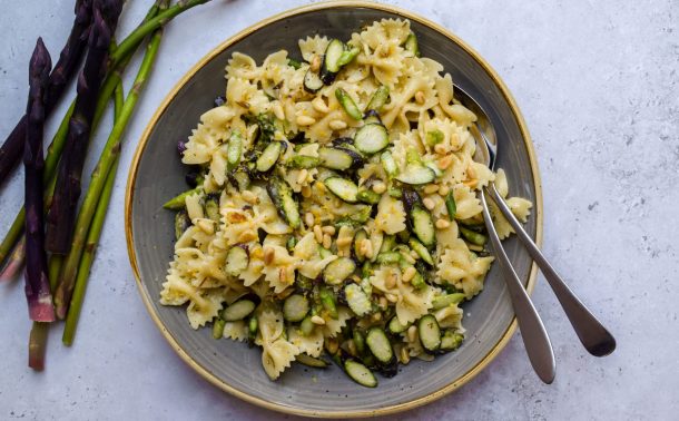 Grey bowl of pasta salad with shaved asparagus.