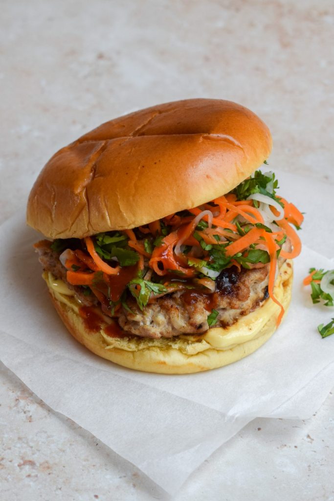 A Pork Banh Mi Smash Burger filled with carrot, coriander and daikon slaw.