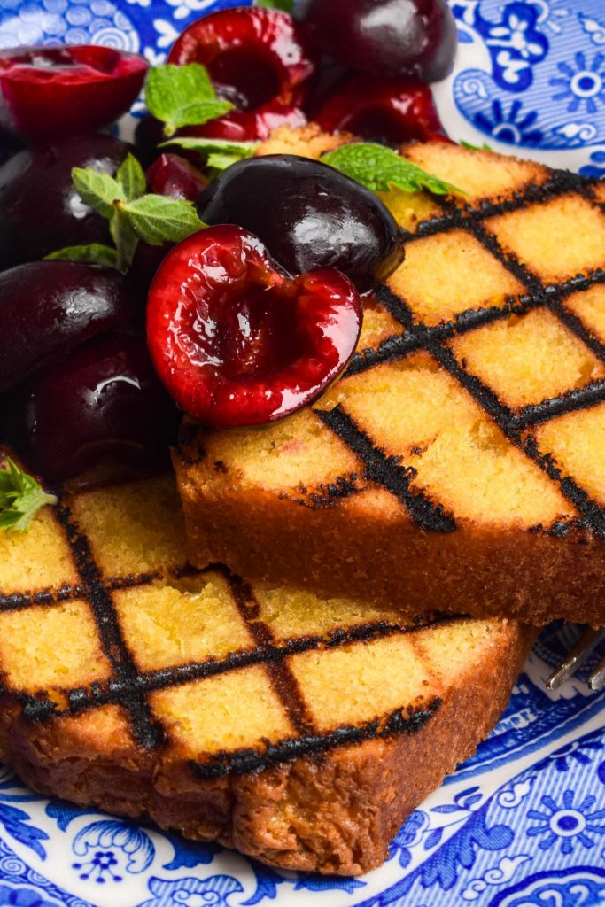 Close up of grilled cake slices with halved cherries.