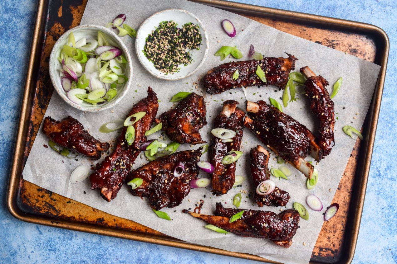 A tray of Chinese spare ribs on a blue background.