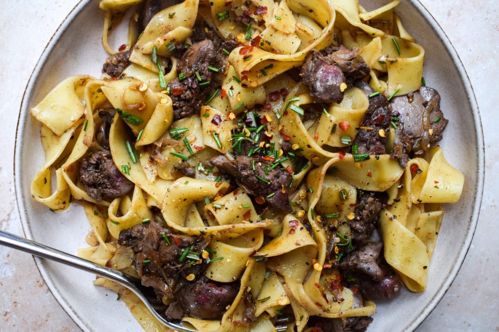Chicken Liver Pappardelle close up with chopped rosemary and chilli flakes