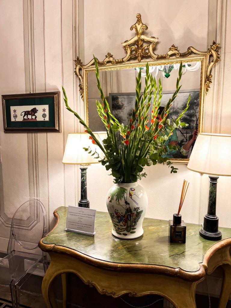 Vase of flowers and lamps on a table in the lobby at Palazzo Feroci