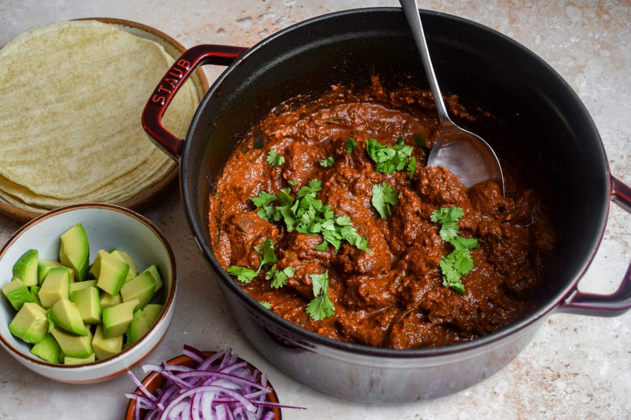 Lamb Birria in a wine red casserole dish.