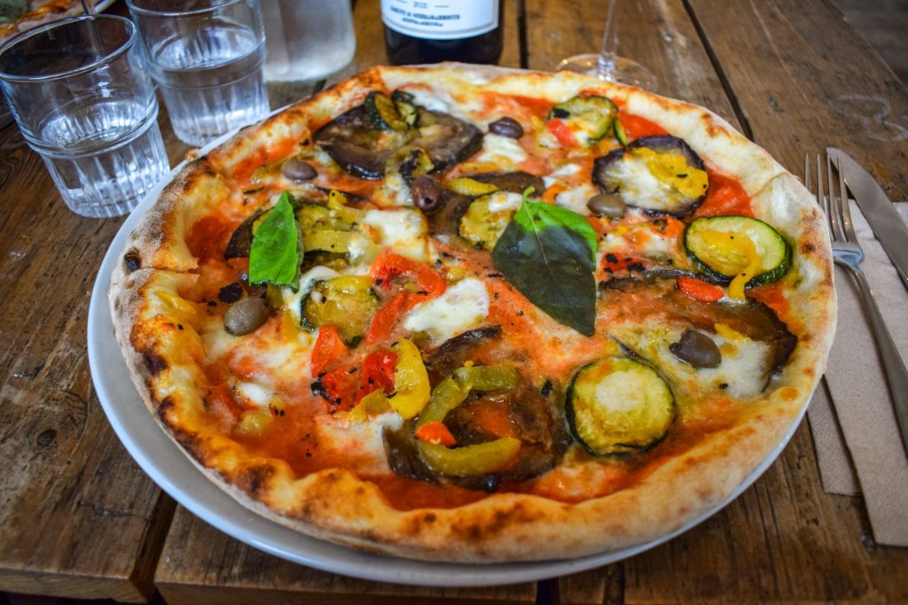 Roasted vegetable pizza on a white plate.