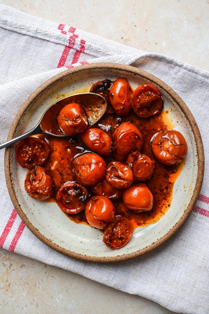 Harissa roasted tomatoes in a stone dish.