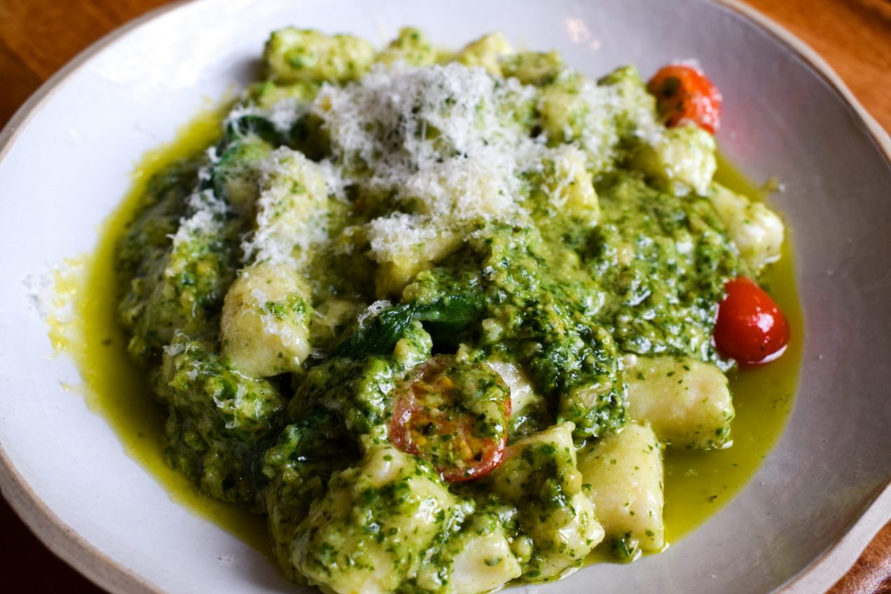 Plate of ricotta and cherry tomatoes tossed with wild garlic pesto.