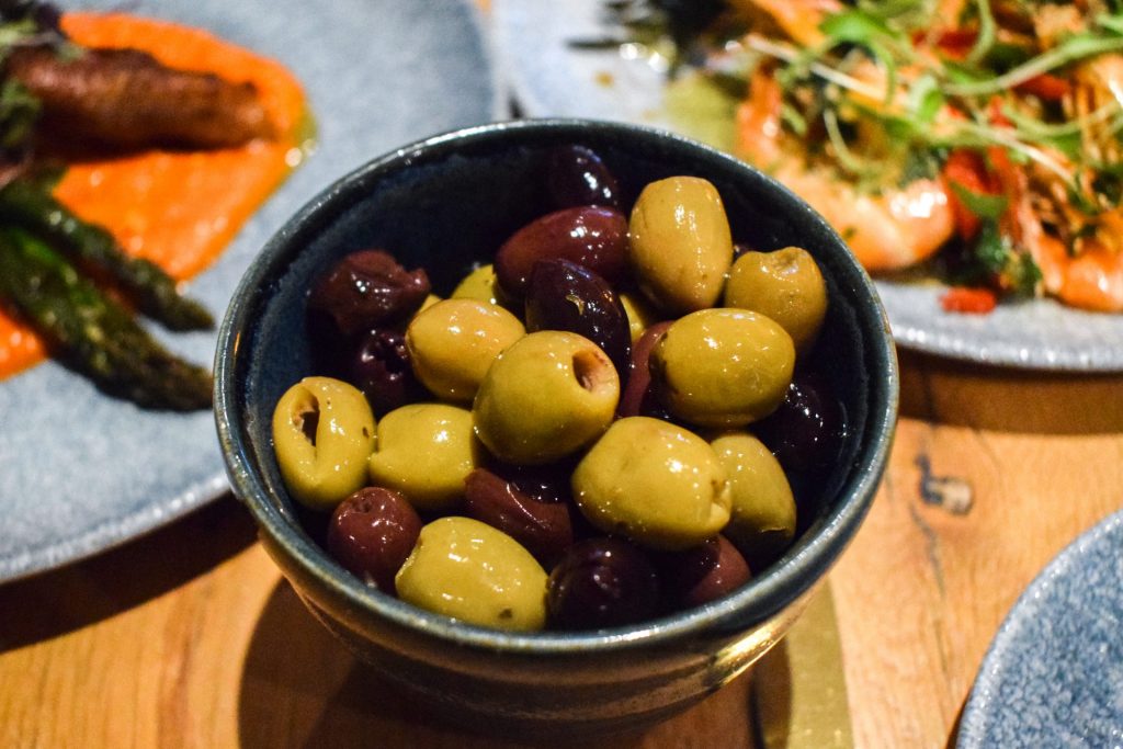 Blue stone bowl of mixed olives.