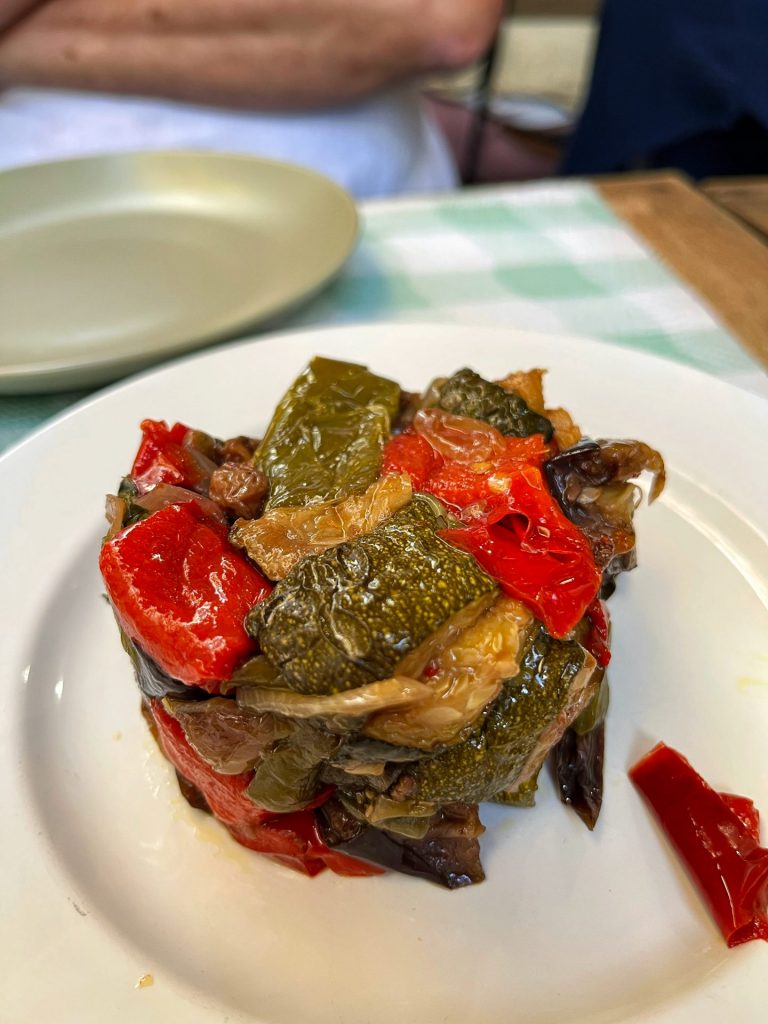 Stacked caponata on a white plate.