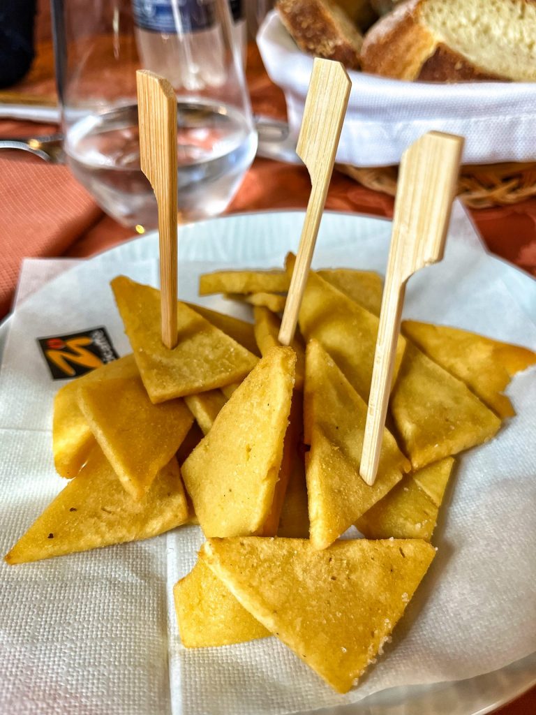 Plate of chickpea fritters with wooden toothpicks.