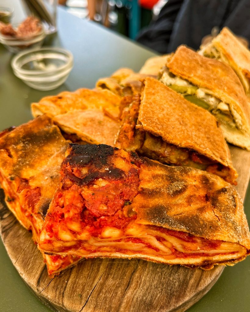 Piles of Scacciata on a wooden serving board.