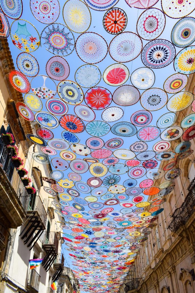 Embroidered art stretched across the top of a street.