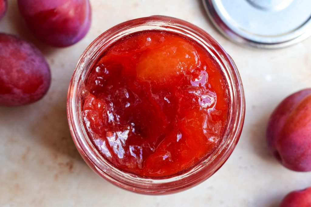 Close up overhead shot of a jar of plum jam.