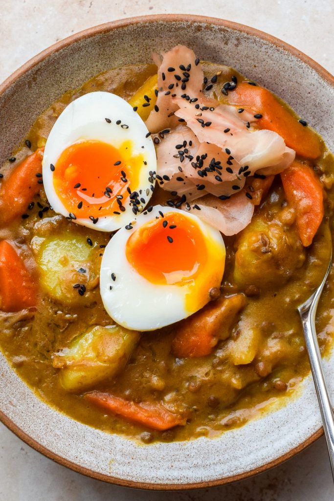 Close up of a bowl of Japanese curry with potatoes, carrots and lentils.
