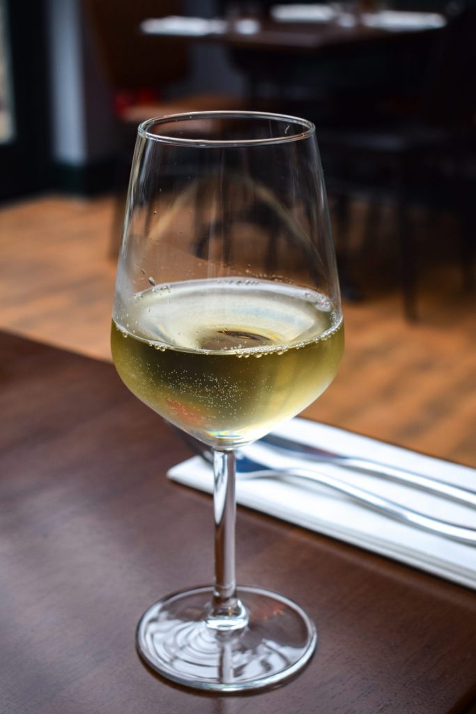 Glass of white wine on a restaurant table.