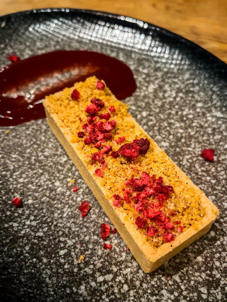 Norwegian brown cheese tart topped with freeze dried raspberry pieces.
