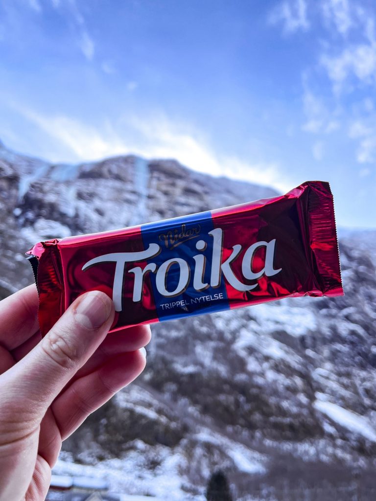 A Troika bar being held up against a snowy Norwegian mountain.
