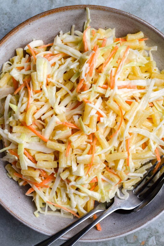 Close up of classic coleslaw with small macaroni shapes.