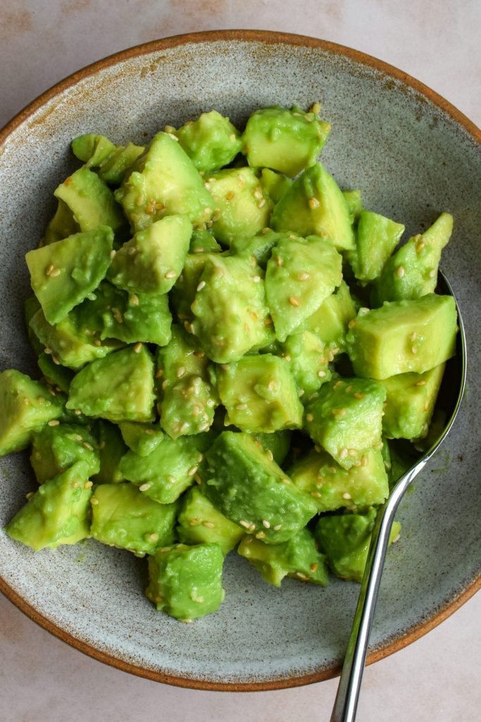Close up of a stone bowl of sesame avocado salad.