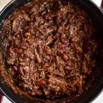 Pot of short rib chili with kidney beans pictured close up.
