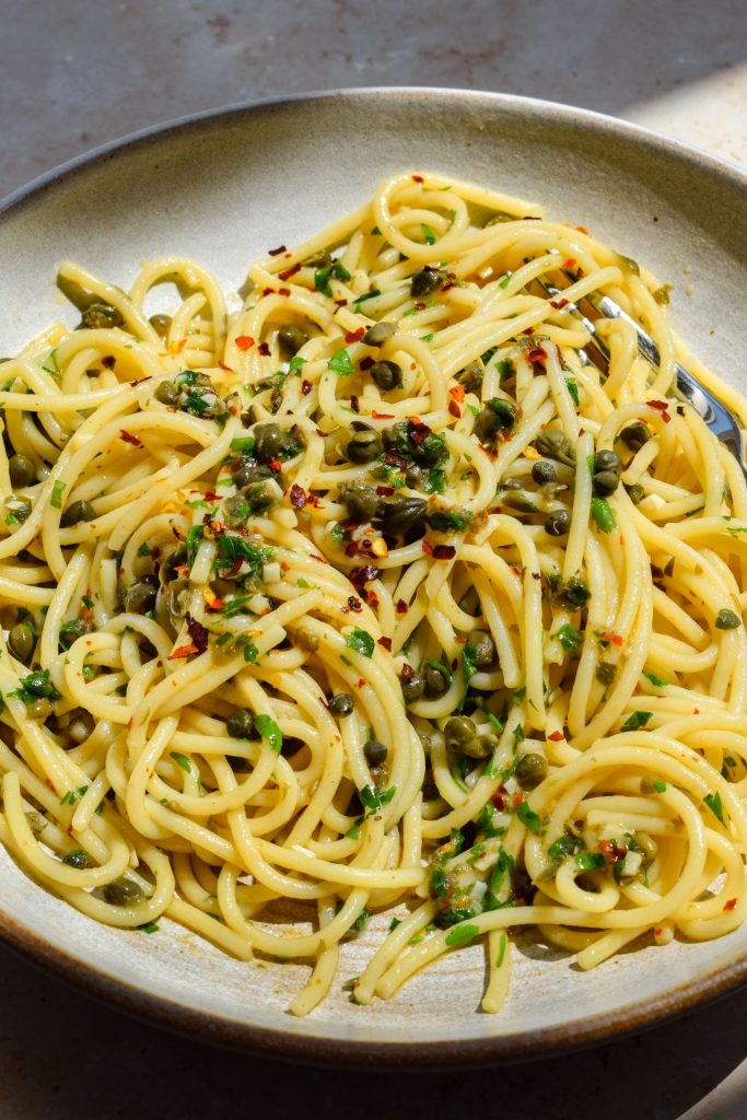Close up of a bowl of caper and chilli spaghetti