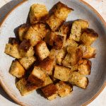 Focaccia Croutons in a stone bowl in direct sunlight.