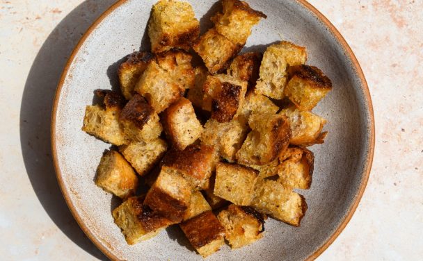 Focaccia Croutons in a stone bowl in direct sunlight.